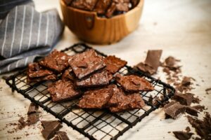 A pile of chocolate cookies sitting on top of a cooling rack